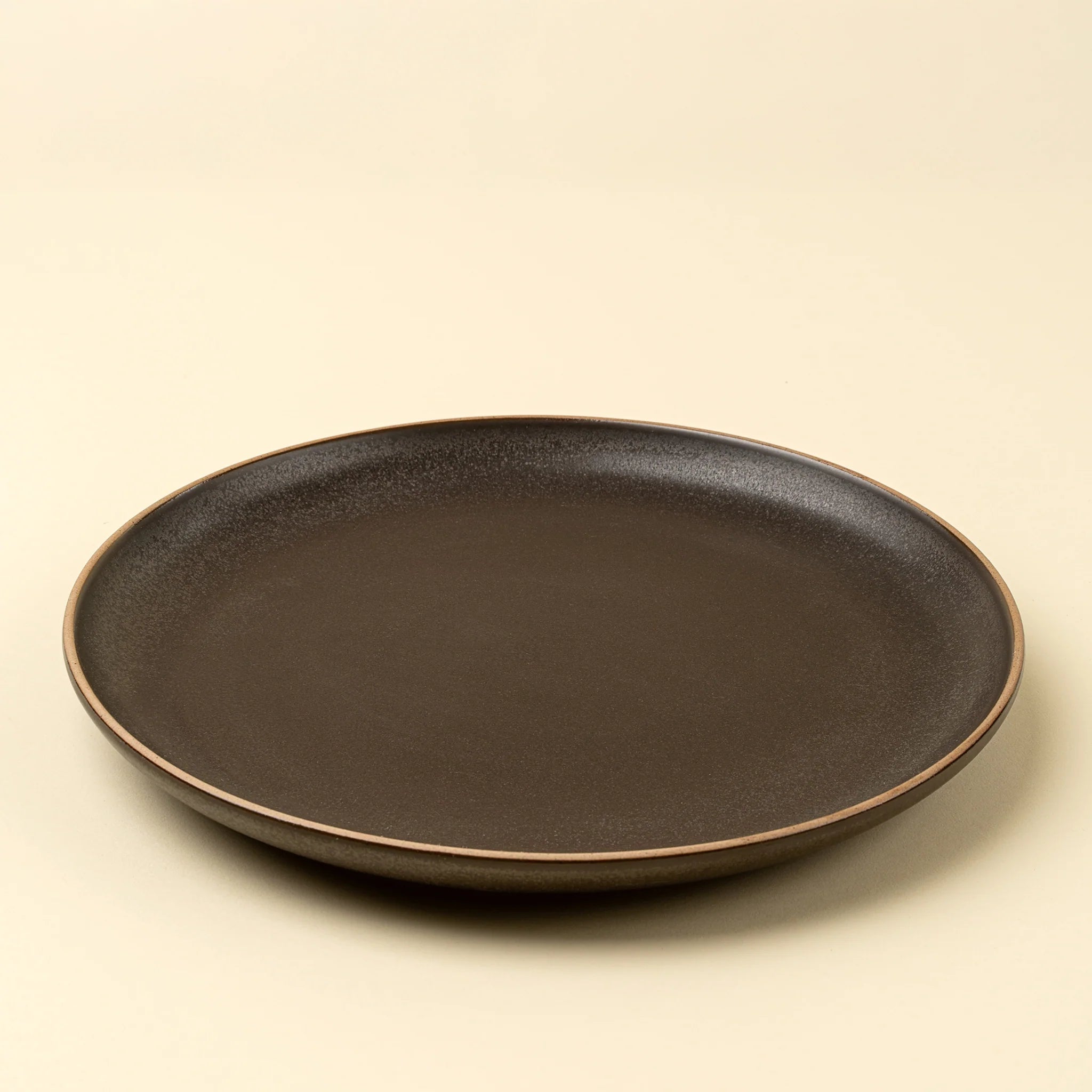 Black ceramic plate on a beige background