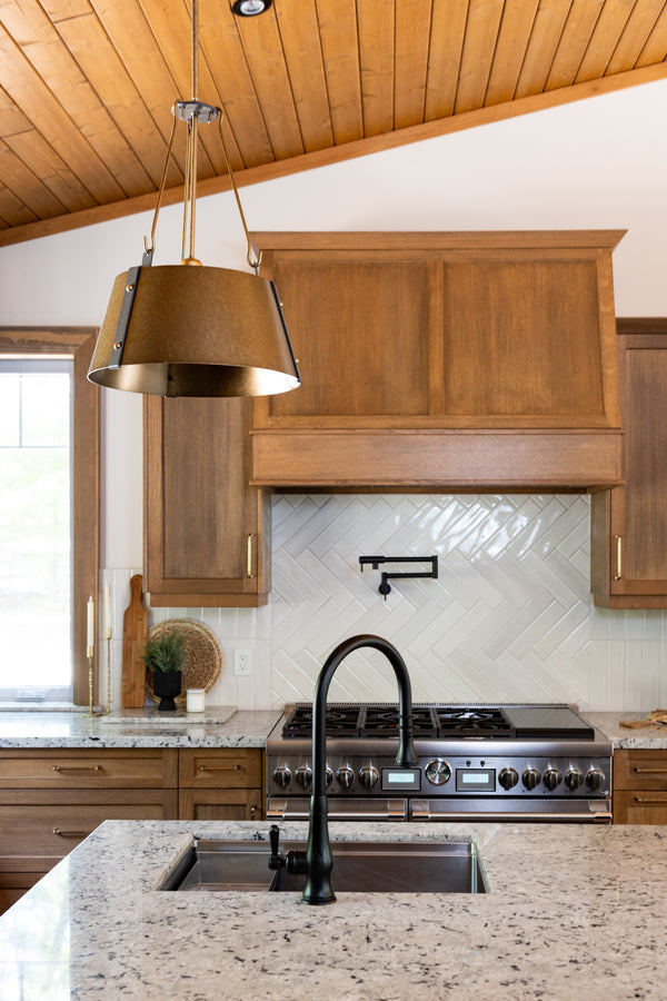 Modern kitchen with wooden cabinets, stainless steel appliances, and a pendant light.